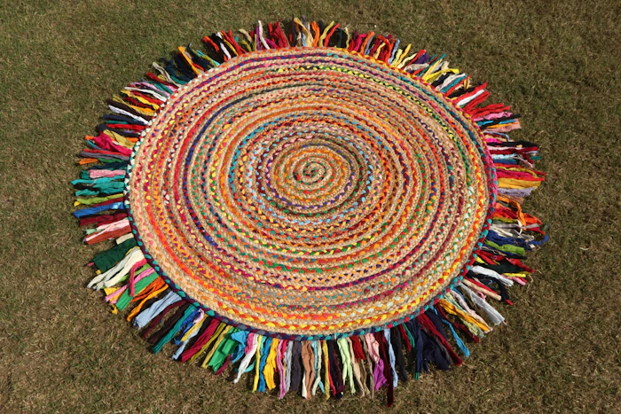 Colourful circular handcrafted rug with a multicolour fringe, photographed from above