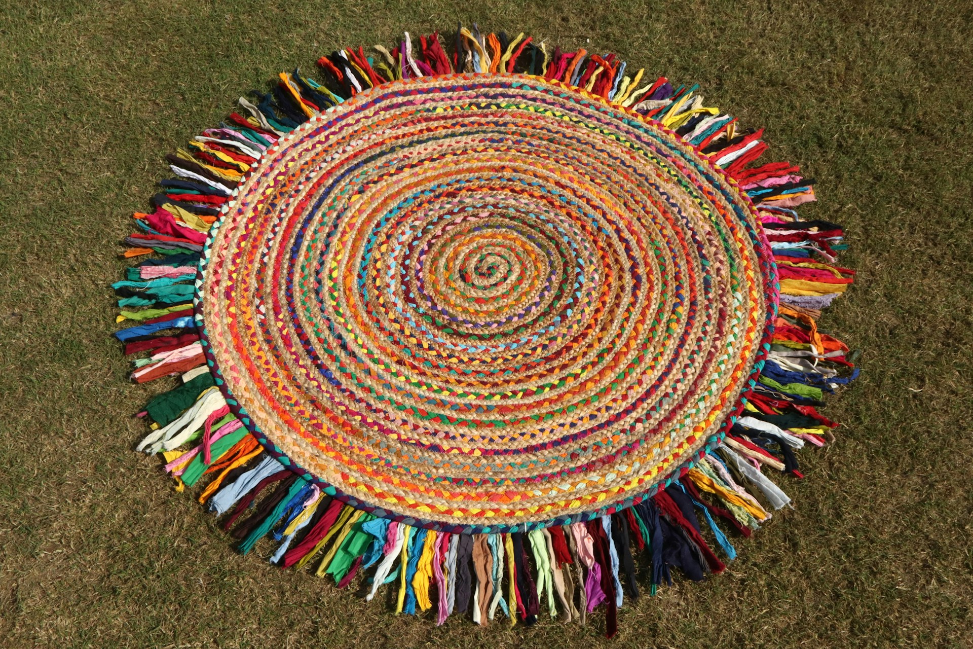 A colorful, circular rug with a fringe.