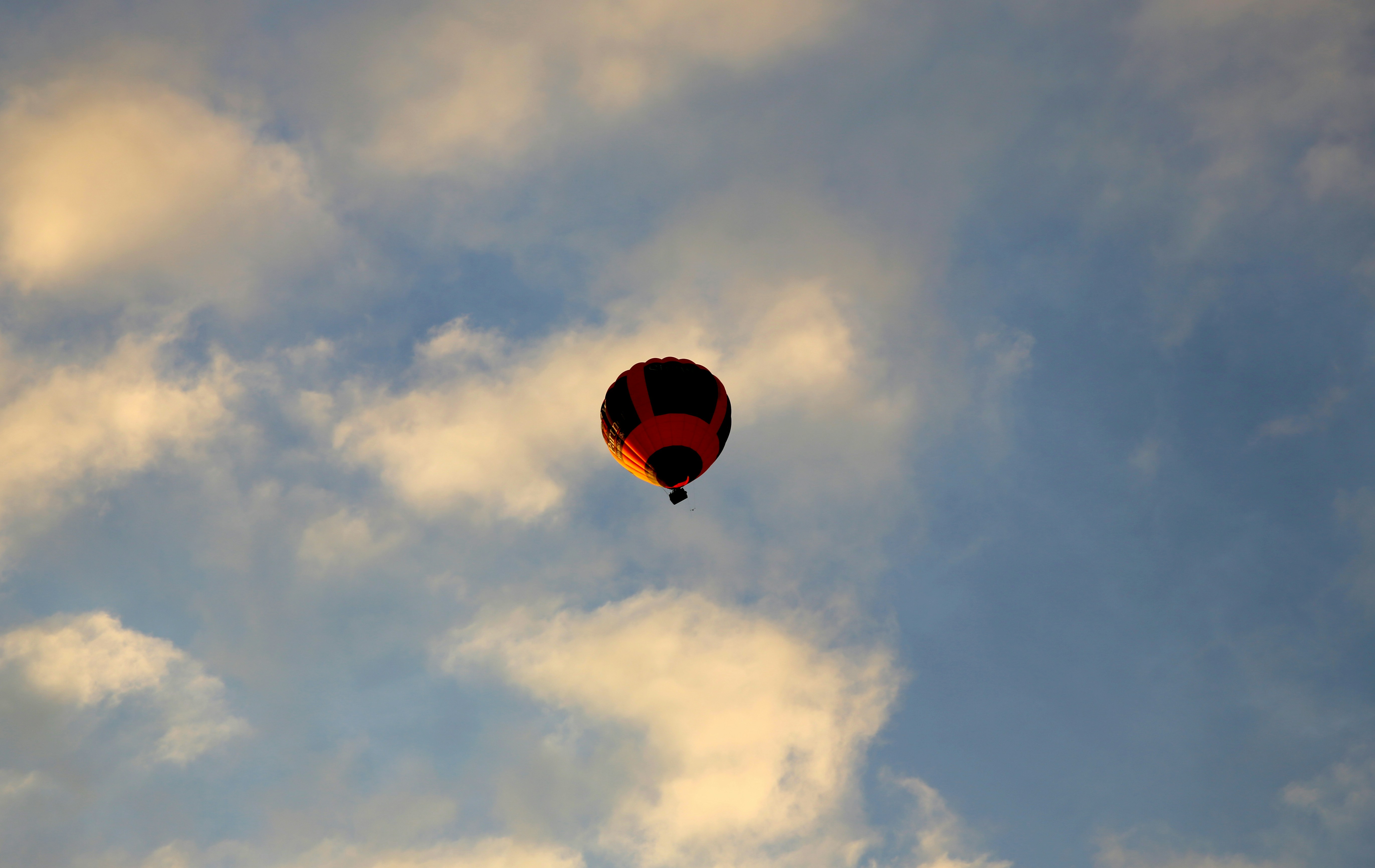A hot air balloon floats amongst clouds.