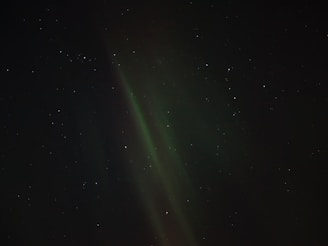 The aurora borealis glows in the night sky.