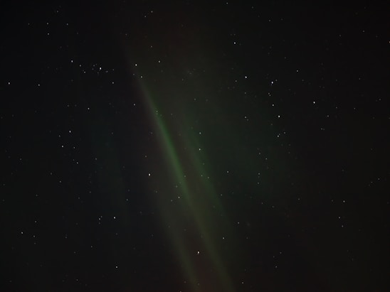 The aurora borealis glows in the night sky.
