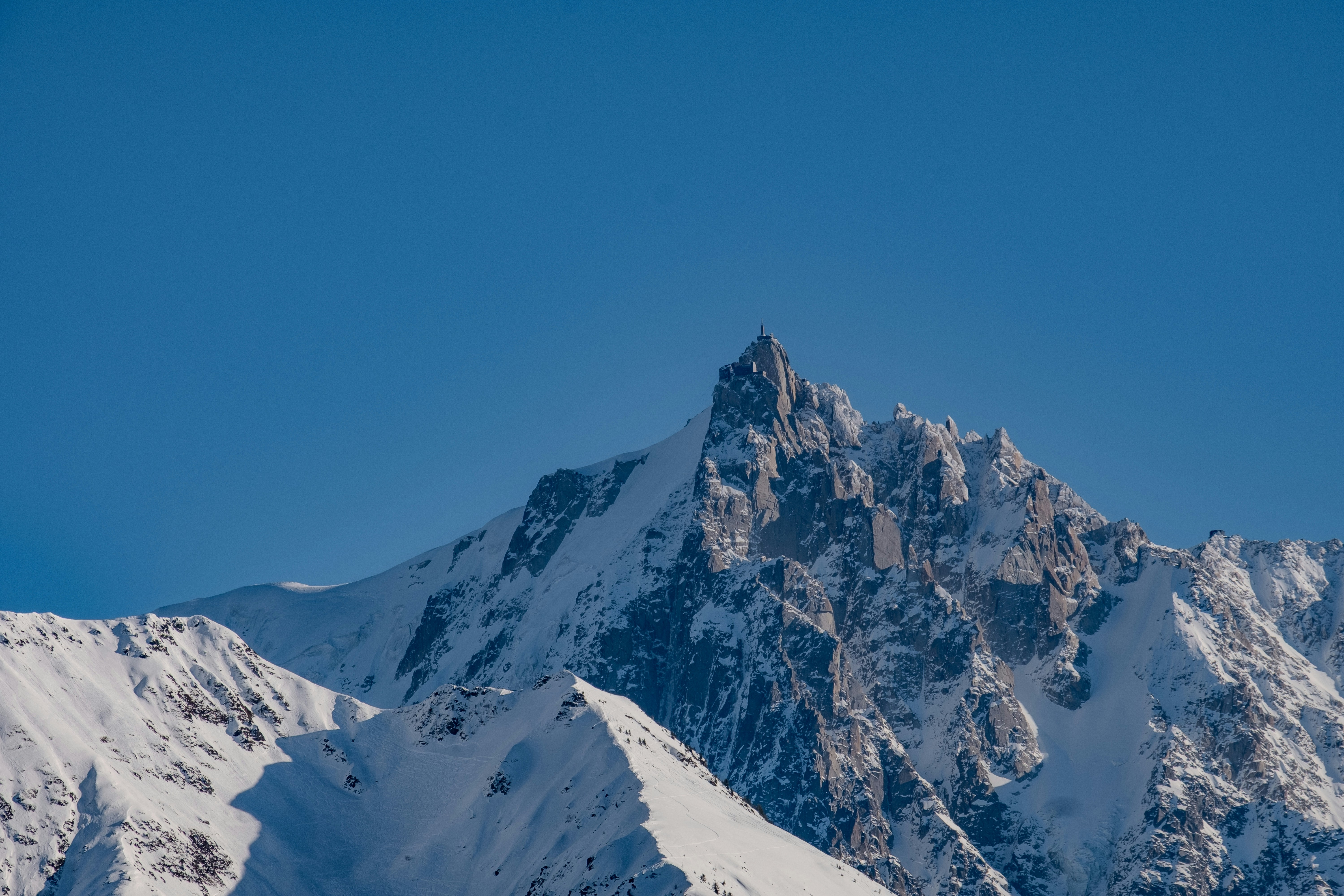 Snowy mountains tower under a clear, blue sky.