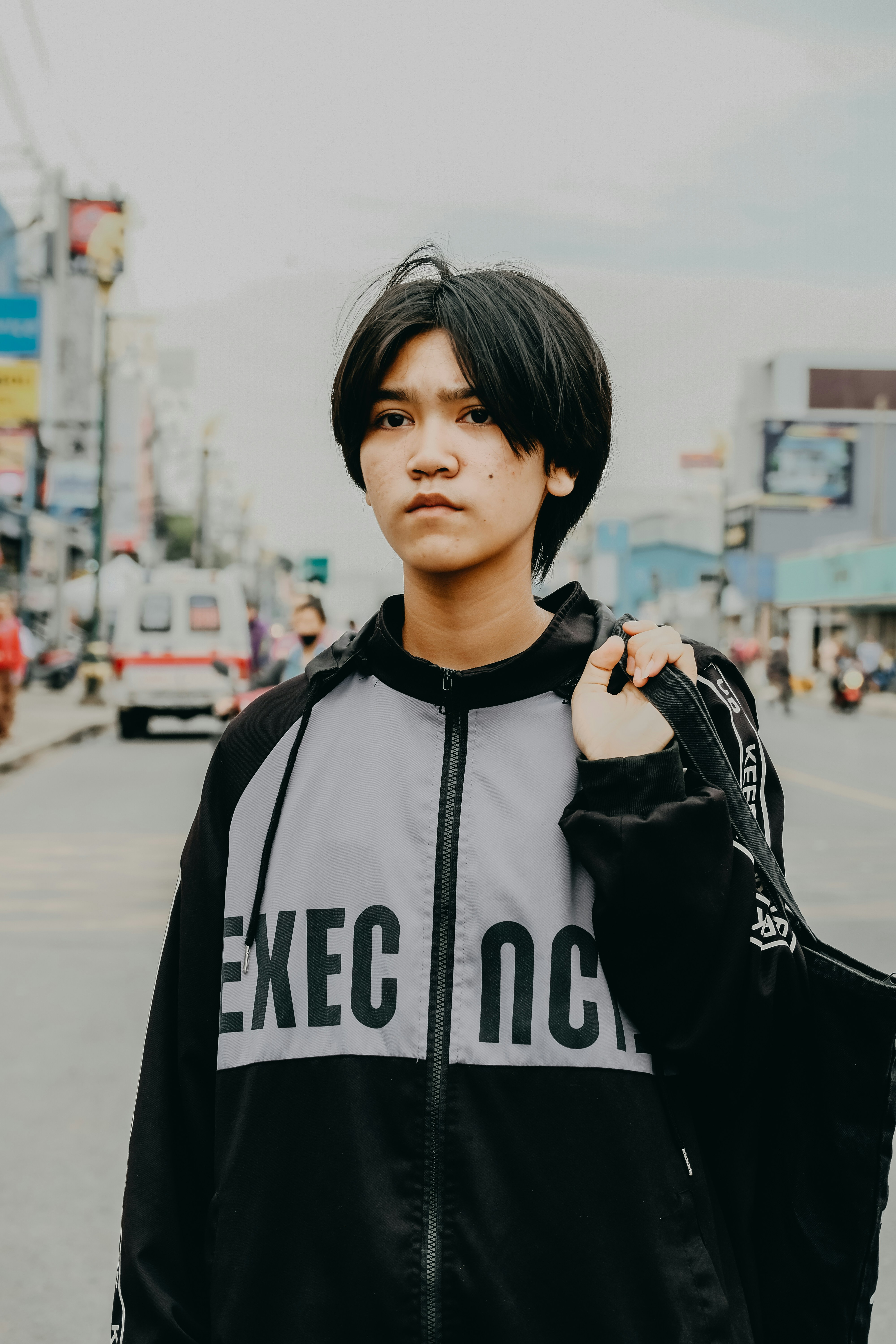 若者は街の通りに立っています。