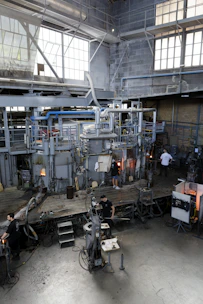 A glassblowing studio with equipment and workers