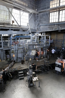 A glassblowing studio with equipment and workers.