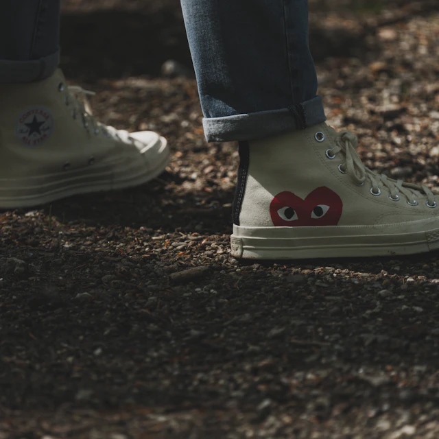 A pair of white Converse sneakers with a heart design