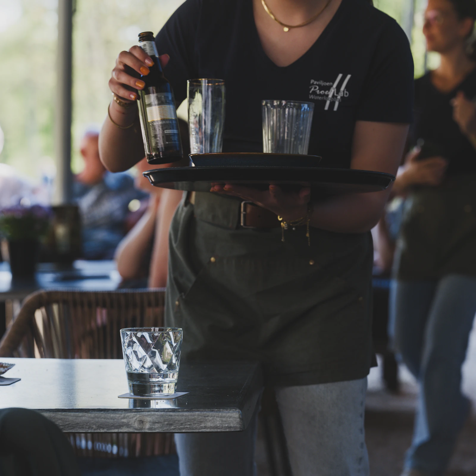 Server carrying a tray of drinks during restaurant service