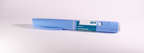 A blue insulin pen rests on a white surface.