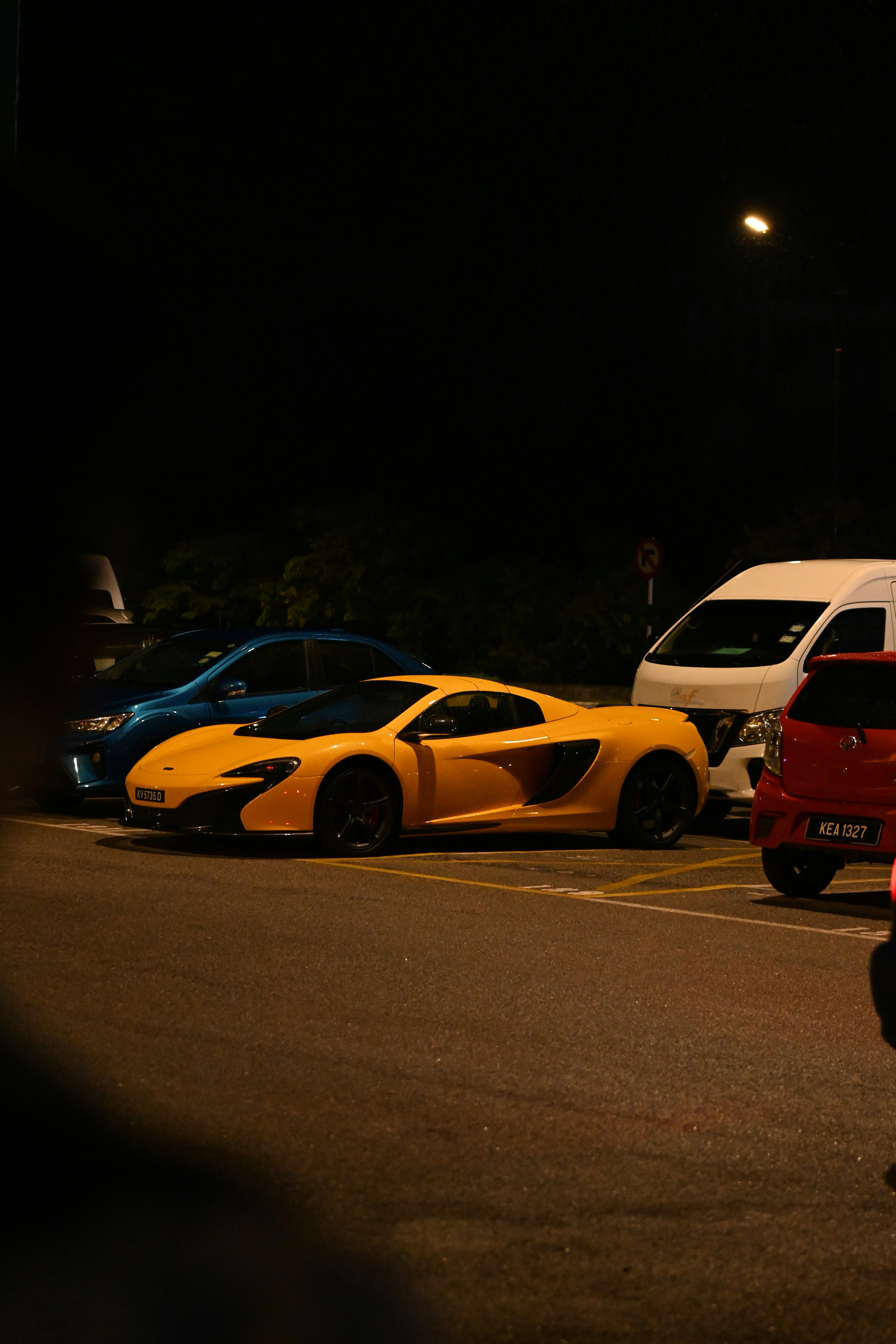 Une voiture McLaren jaune garée la nuit.