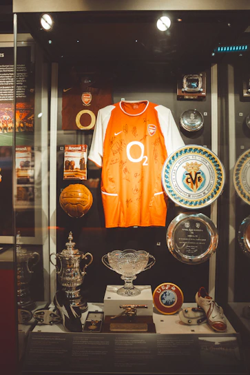 Arsenal football memorabilia displayed in a glass case.