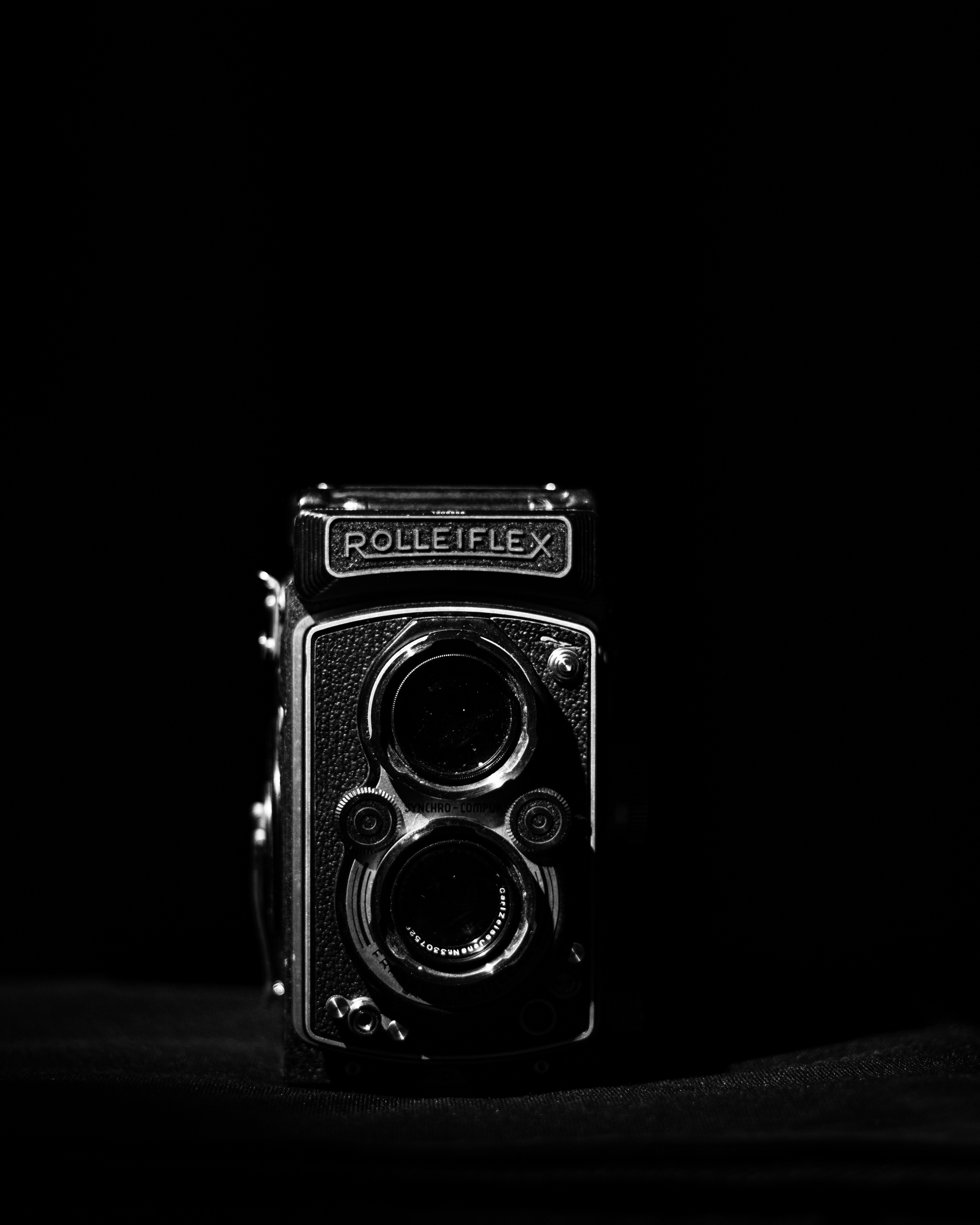 Eine klassische Rolleiflex-Kamera vor schwarzem Hintergrund.