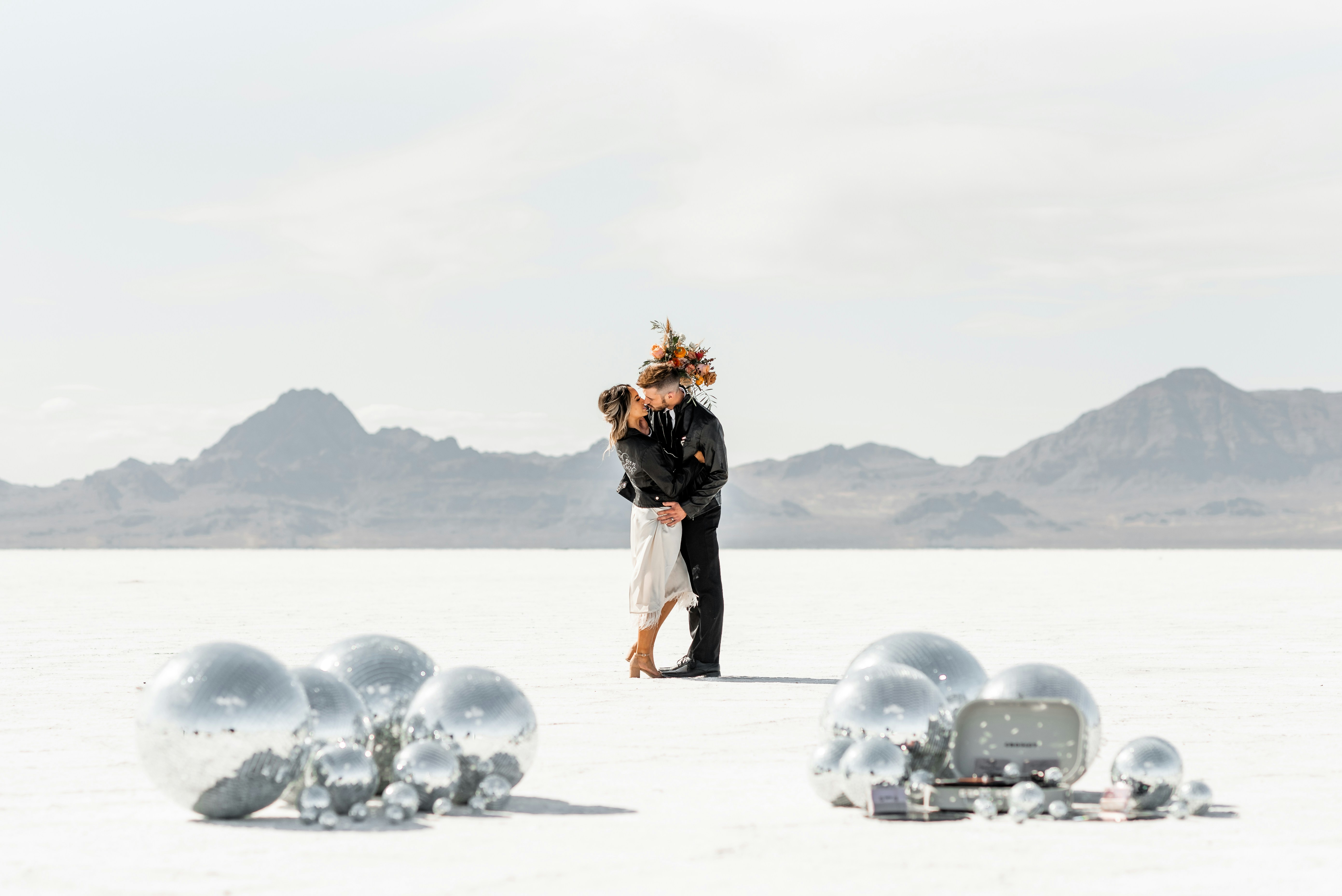 A couple embraces on a salt flat with decorations