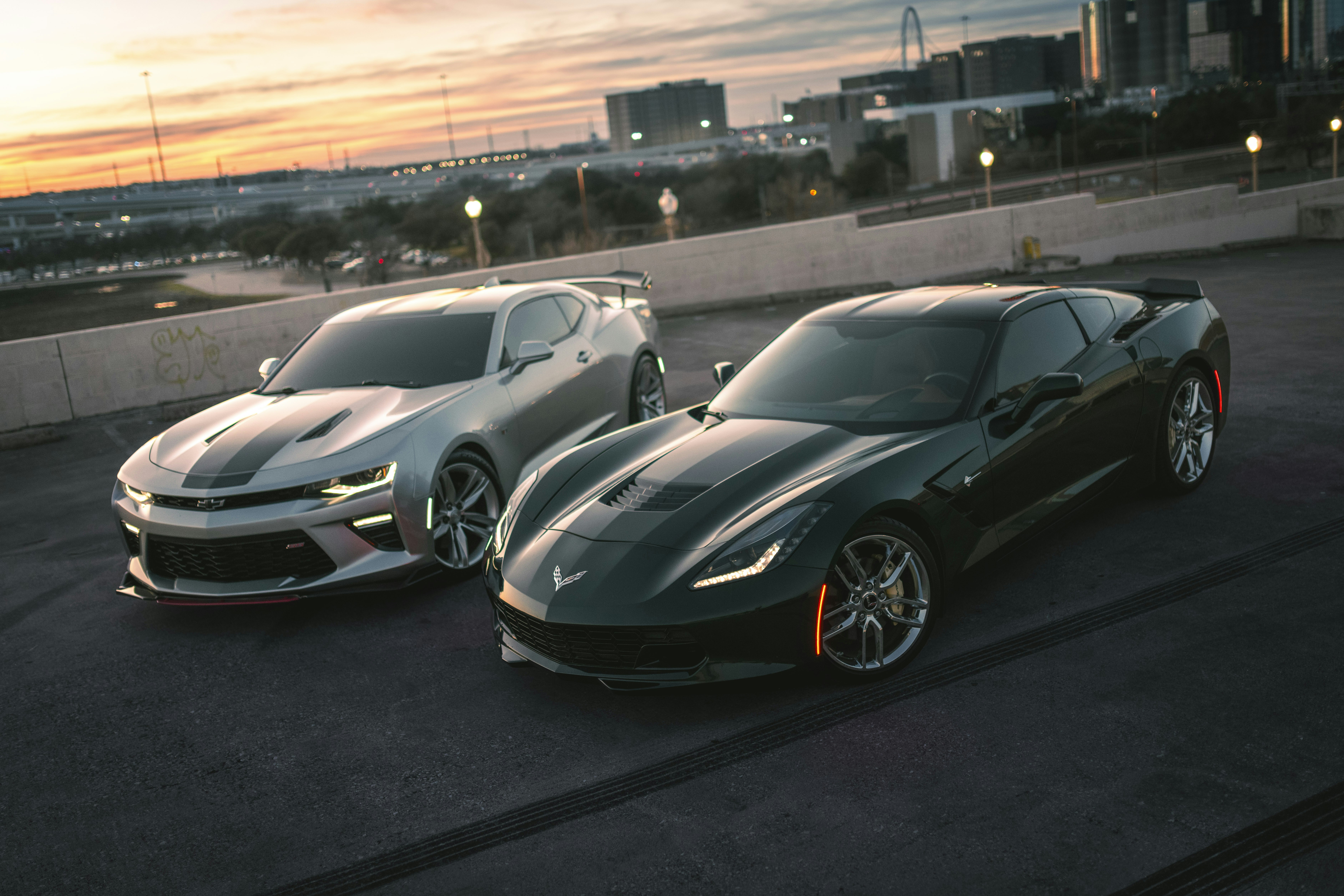 Two sleek sports cars parked at sunset.