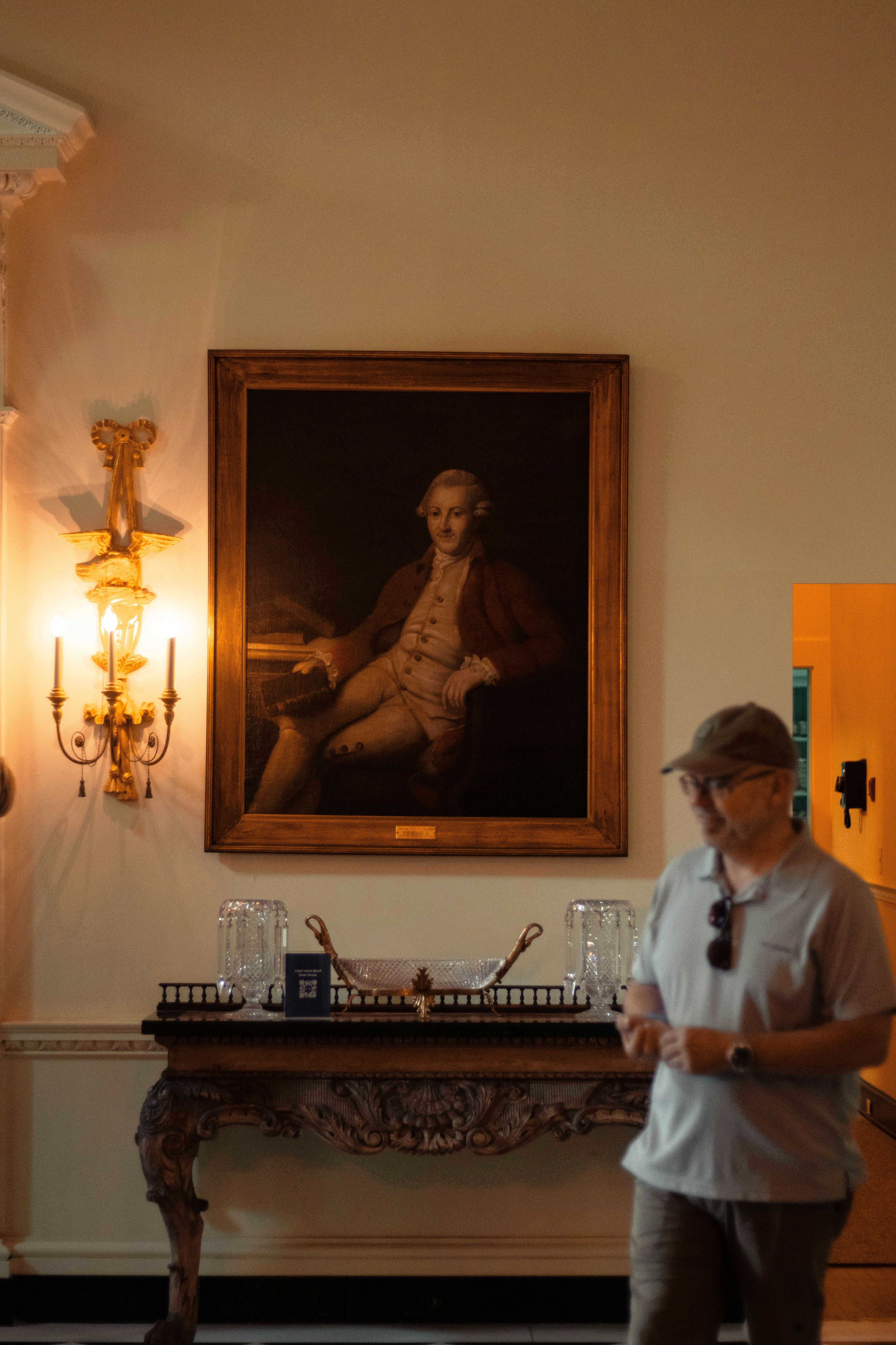 男は優雅な部屋の肖像画を賞賛します。