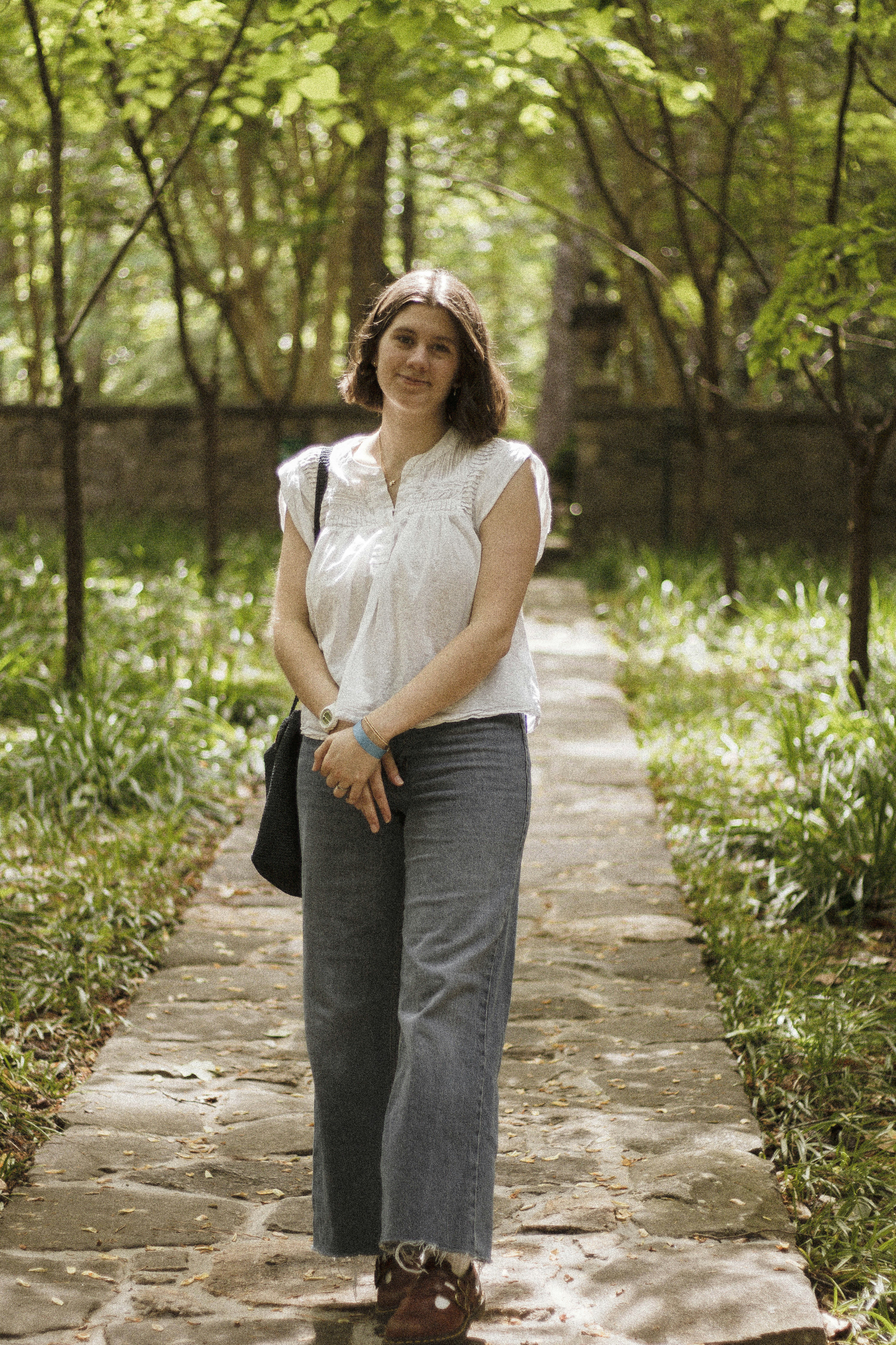 公園の石畳に立つ女性。