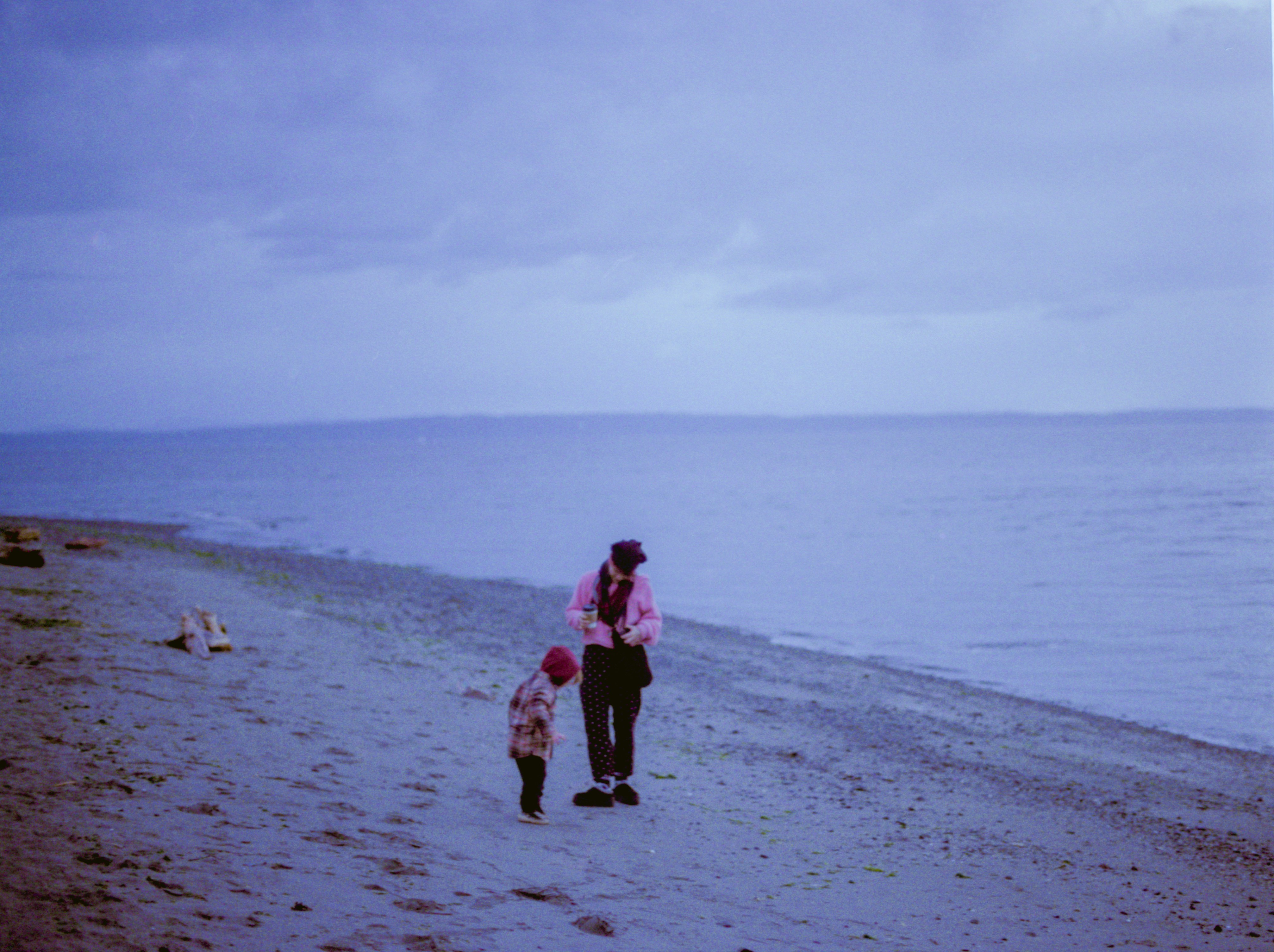 Seseorang dan anak berjalan di pantai.