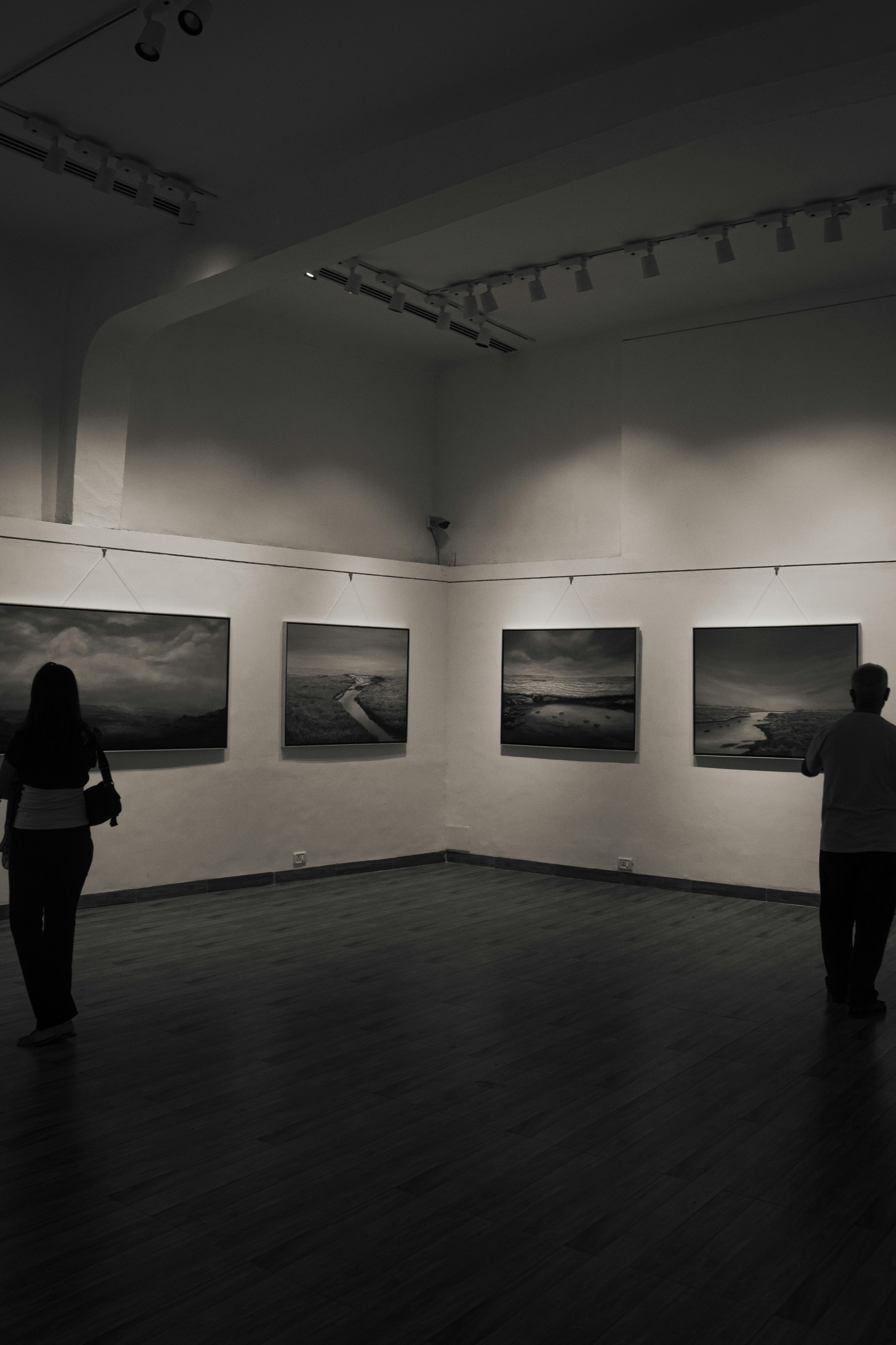 As pessoas veem a arte em um ambiente de galeria.