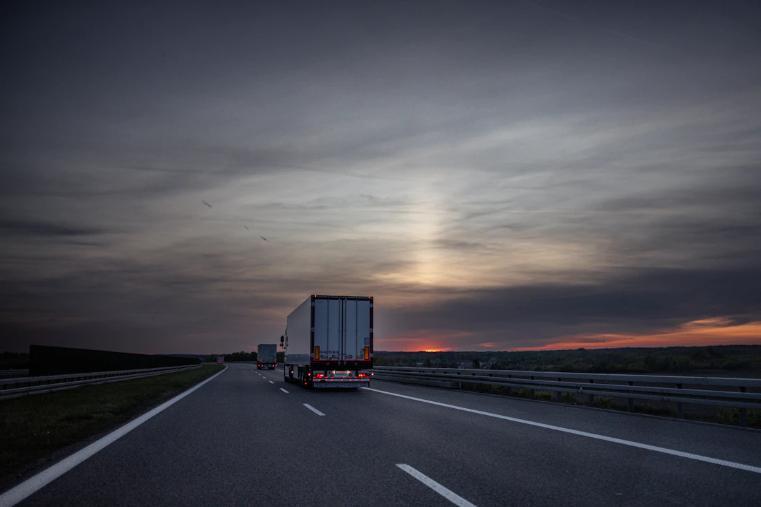 Freight trucks on the highway at sunset