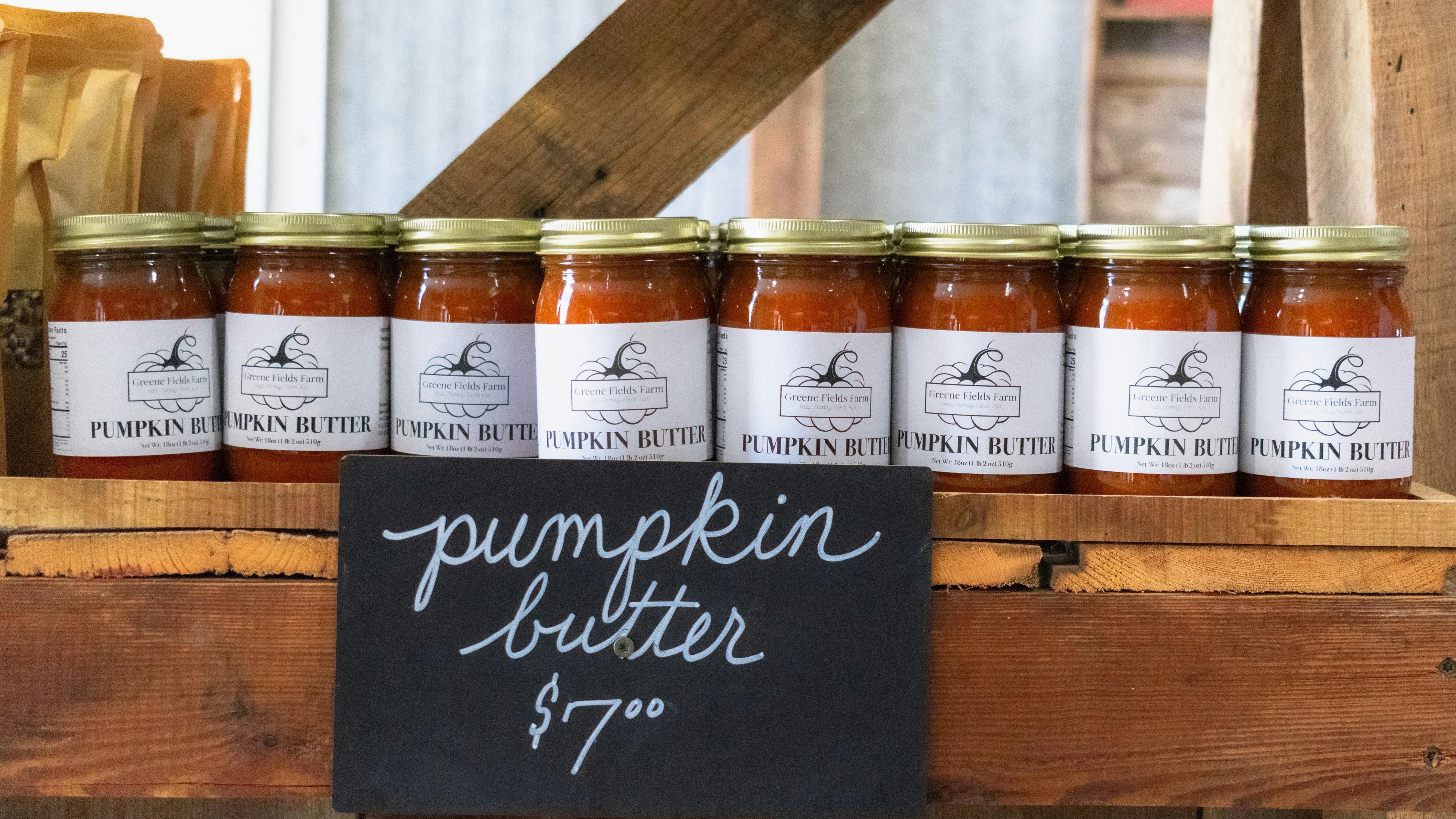 Pumpkin butter jars are displayed on a shelf.