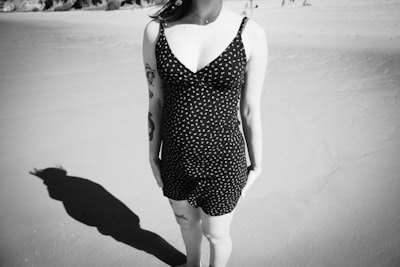 A woman stands on the beach in black and white.