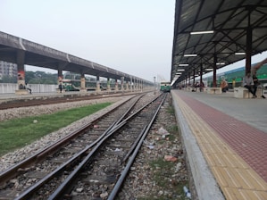 Train tracks lead towards a covered platform.