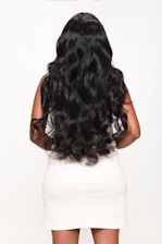 Woman poses with long, flowing, black hair.