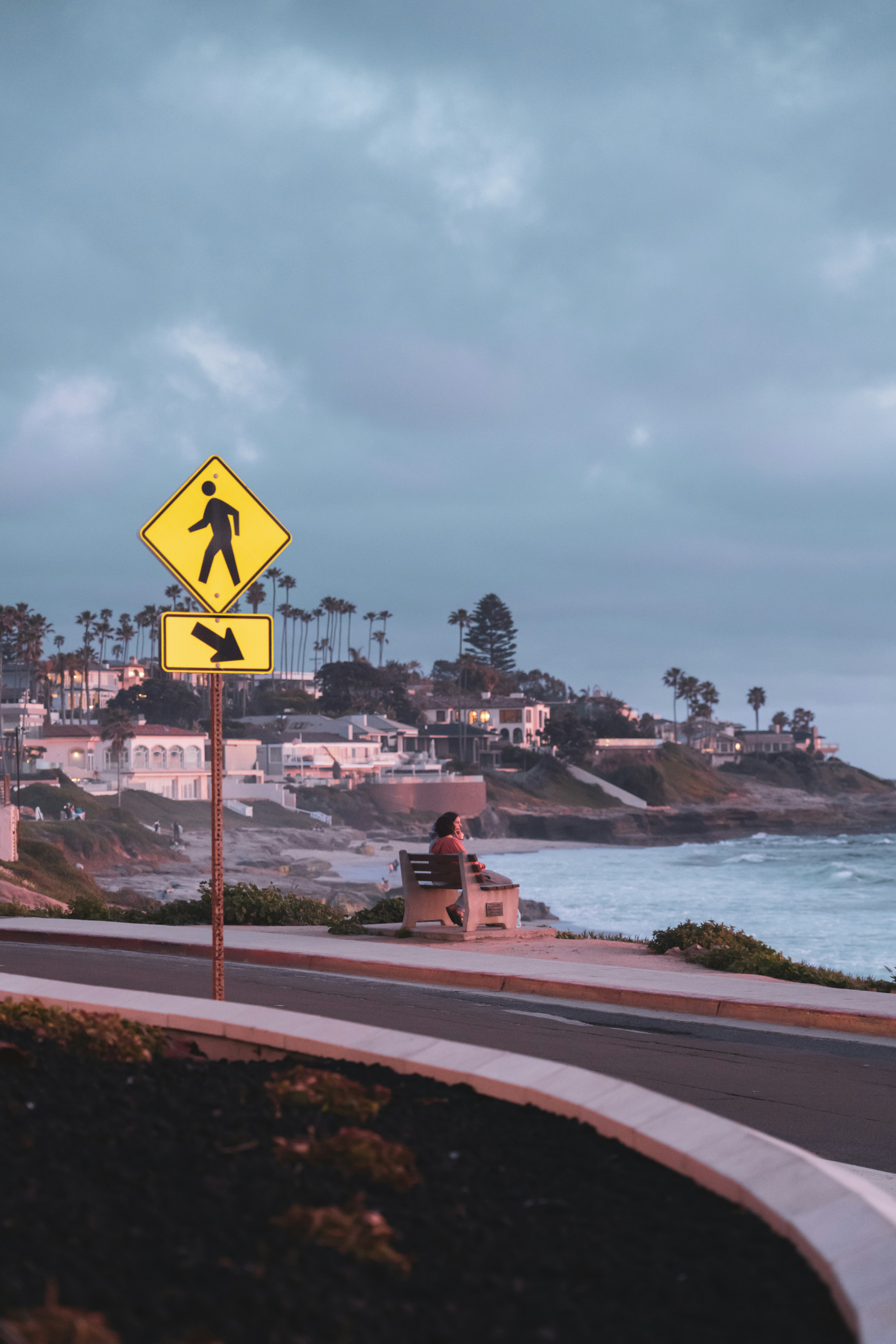 Pedestrian sign overlooking a scenic coastal view.
