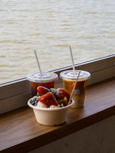 Drinks and dessert sit by the water.