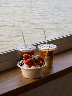 Drinks and dessert sit by the water.