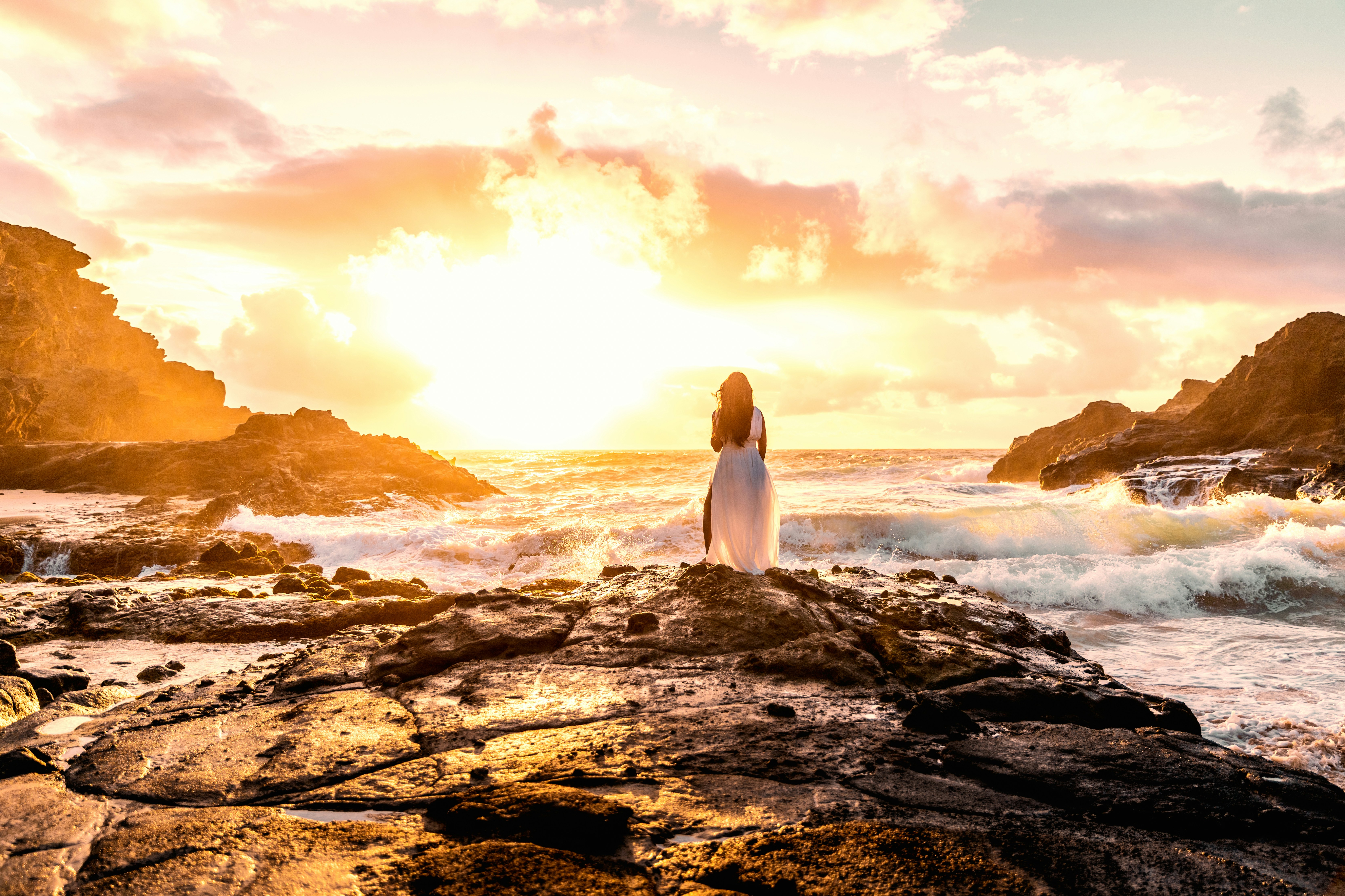Woman watches a stunning sunset over the ocean.