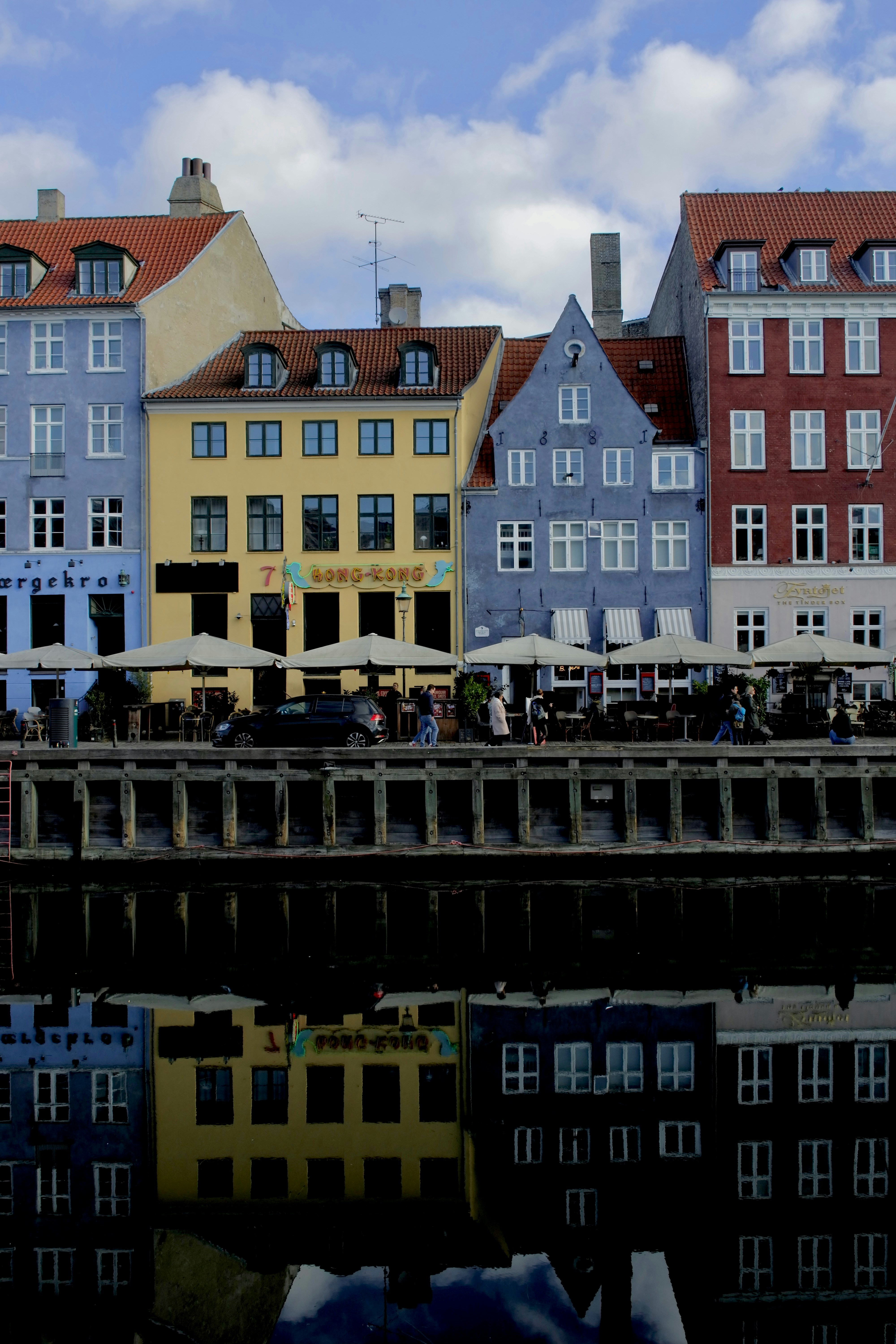 Colorful buildings line a waterfront with their reflection.