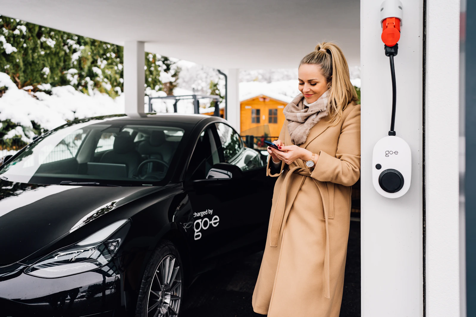 Une salariée recharge son véhicule électrique sur le parking de son entreprise