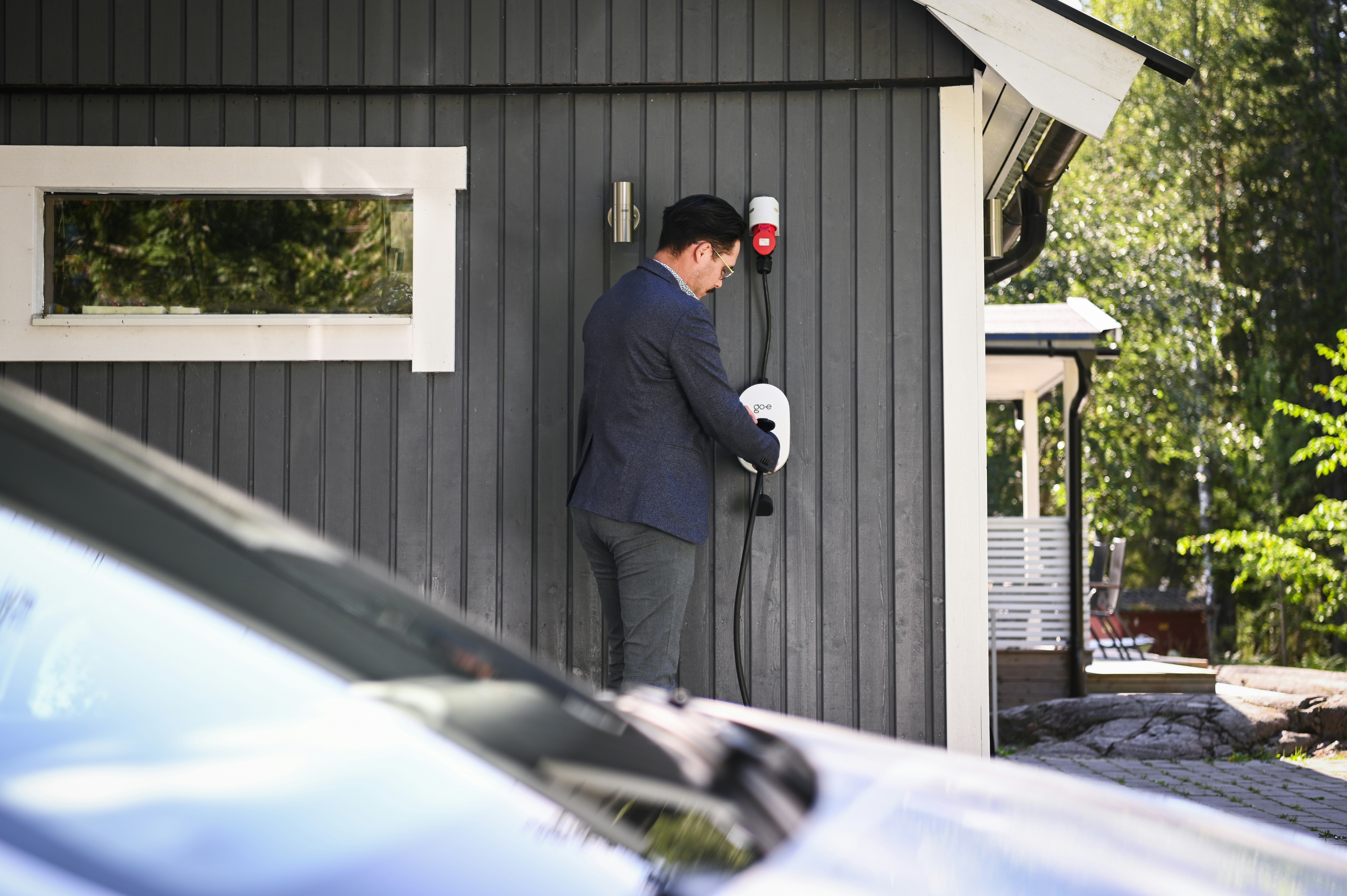 Man plugs in an electric vehicle charging cable.