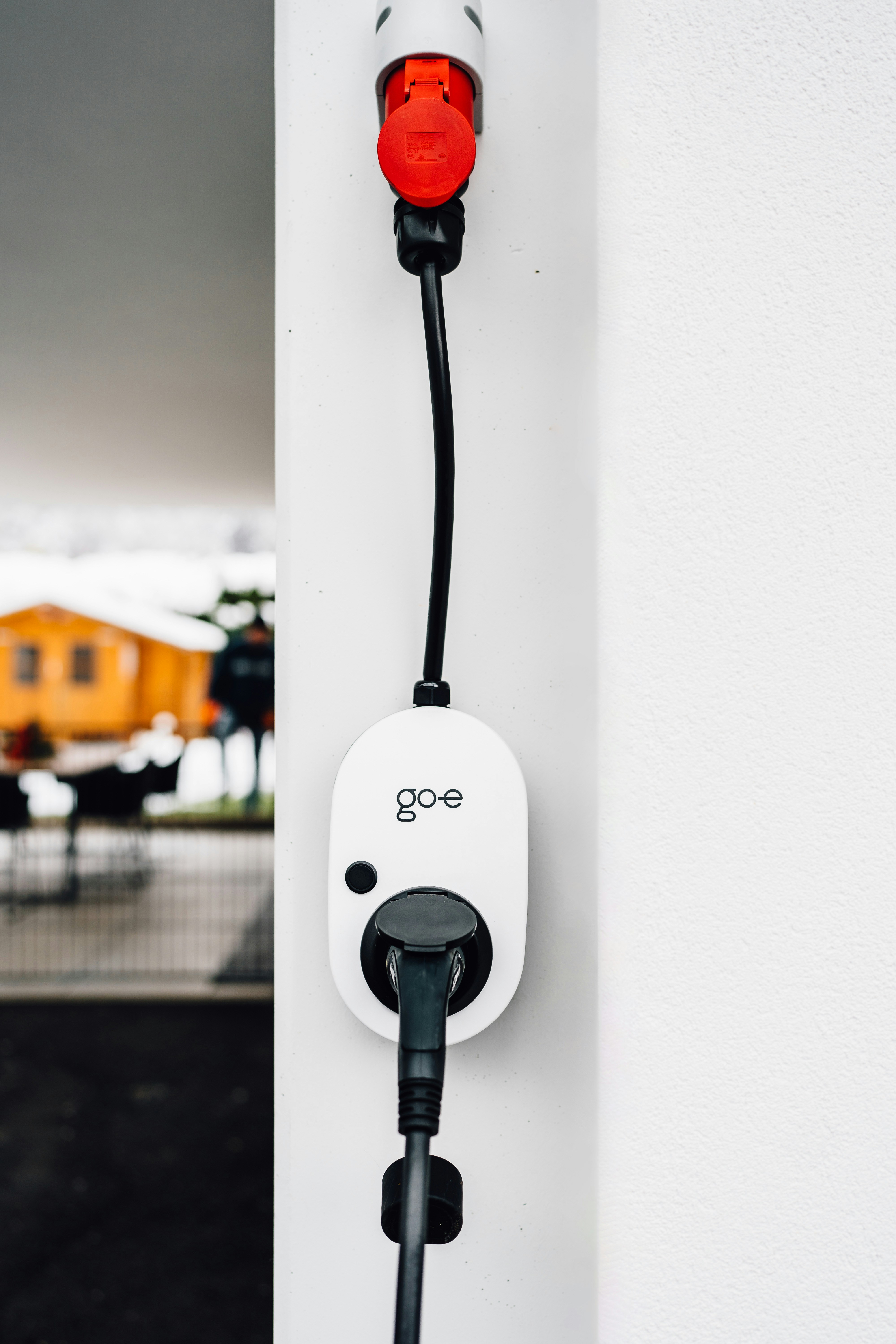 An electric vehicle charger is plugged into the wall.