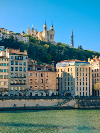Buildings and a church overlooking a tranquil river.