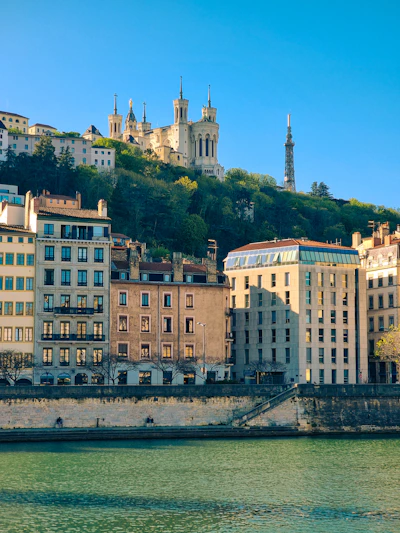 Buildings and a church overlooking a tranquil river.