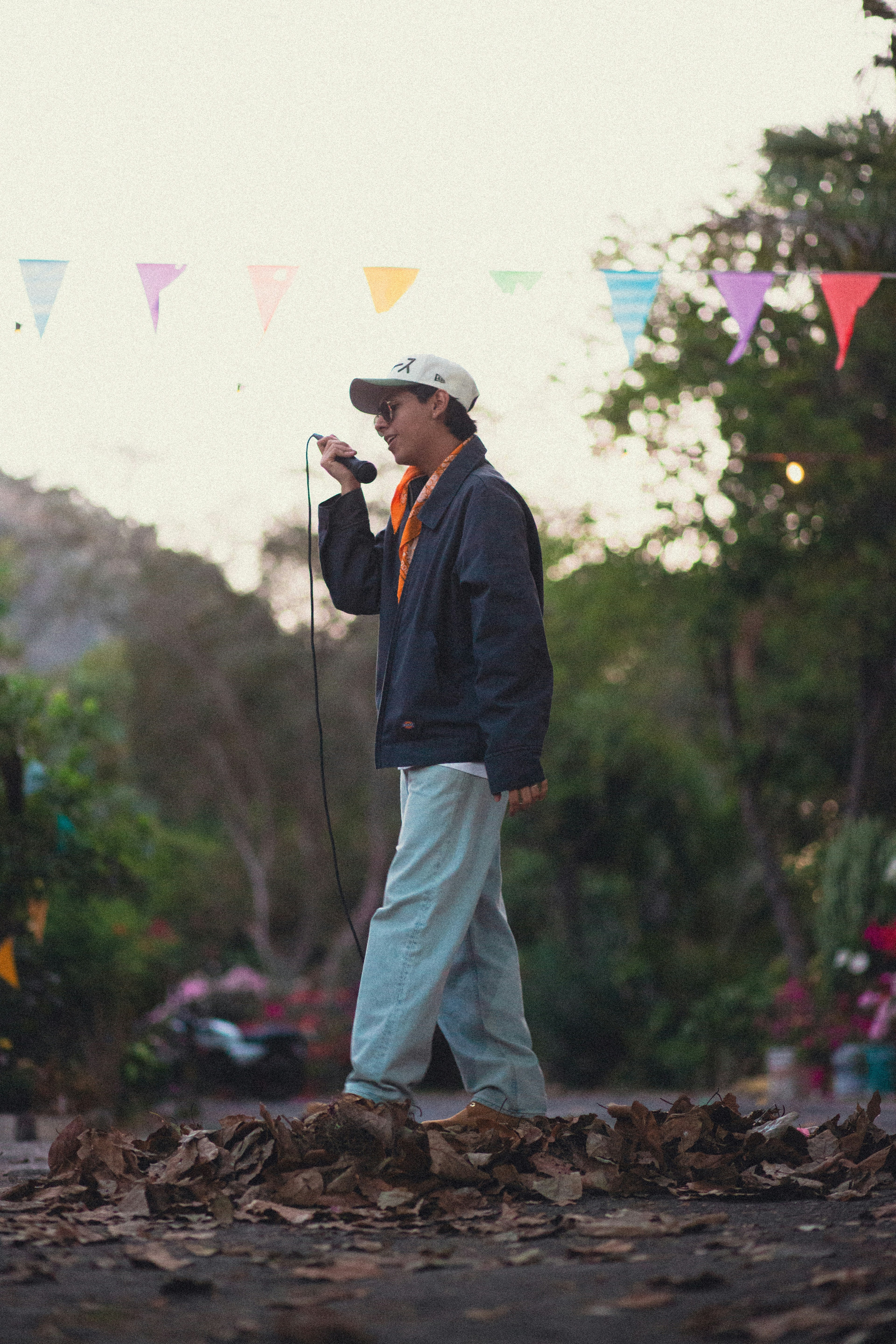 Man holding microphone, walking outdoors with flags