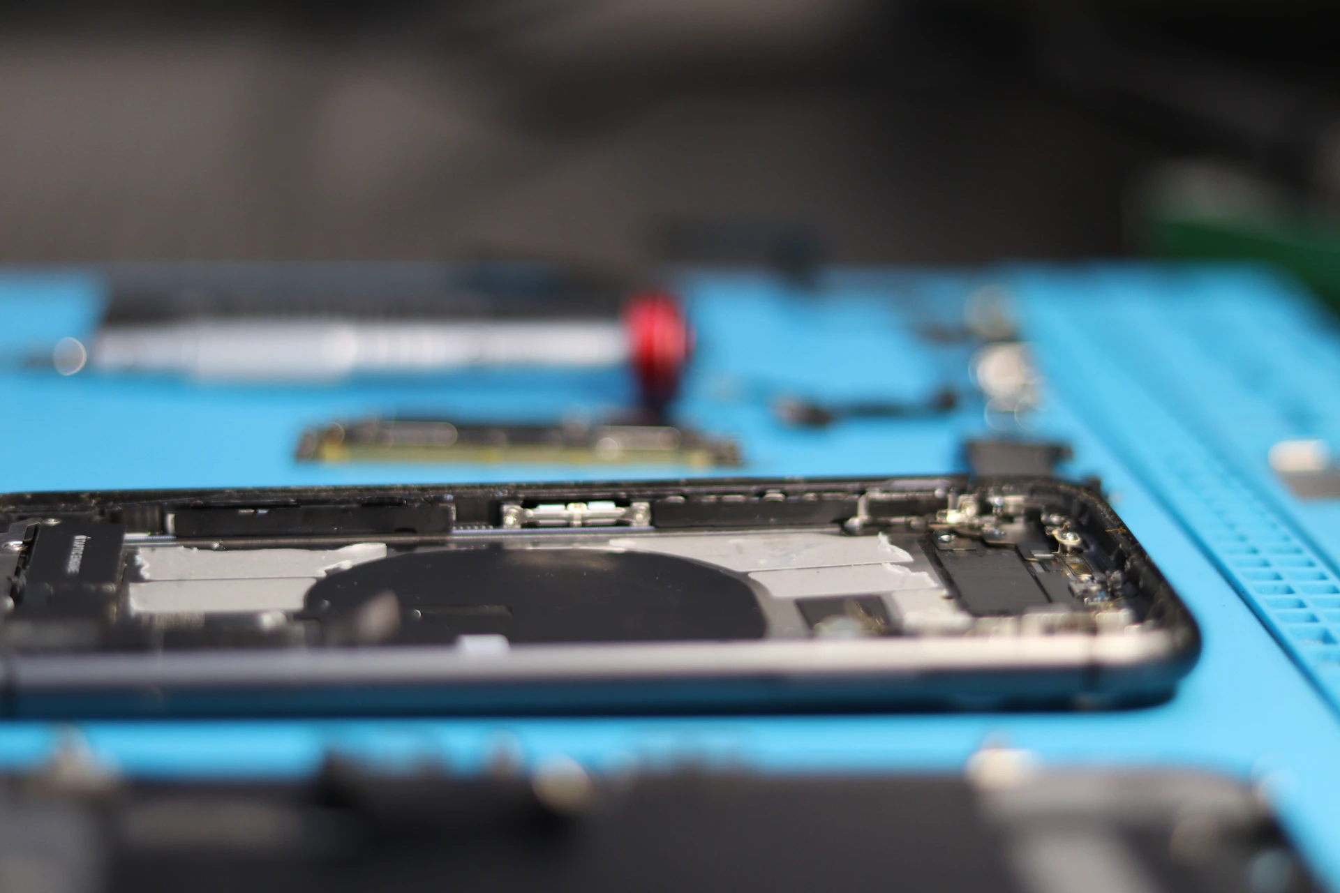 A disassembled phone is being repaired.