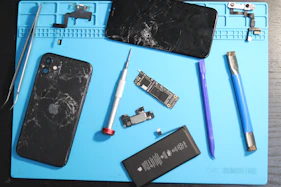 Phone parts scattered on a repair mat.