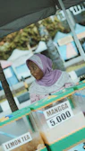 Woman selling mango juice at a market stall.