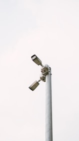 Two security cameras are mounted on a pole.