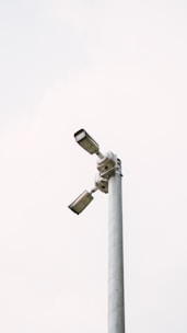 Two security cameras are mounted on a pole.