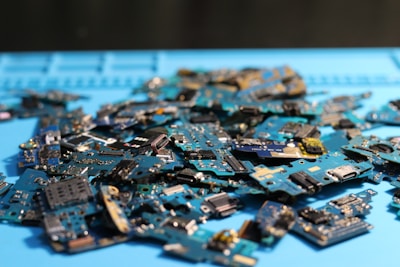 Electronic circuit boards are piled on a surface.