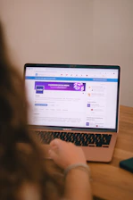A person is using a laptop, browsing a website.