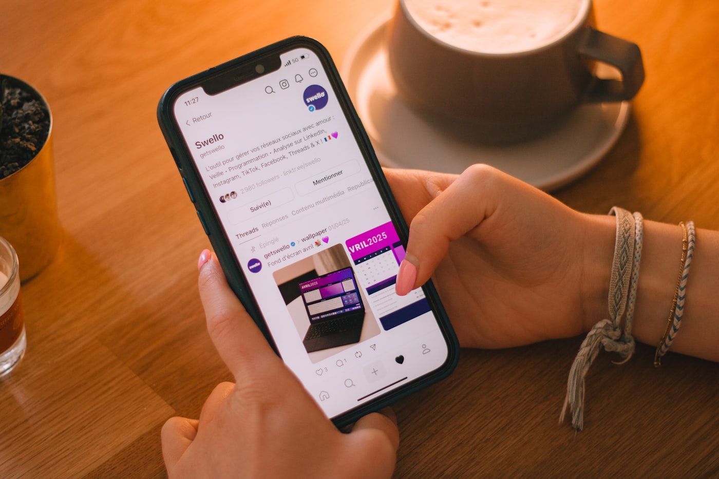 Someone scrolling a social media feed on a smartphone in a dark room, the screen glowing purple