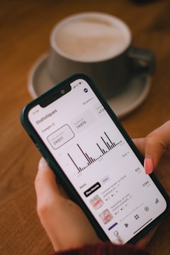 A phone displaying statistics, with coffee in the background.