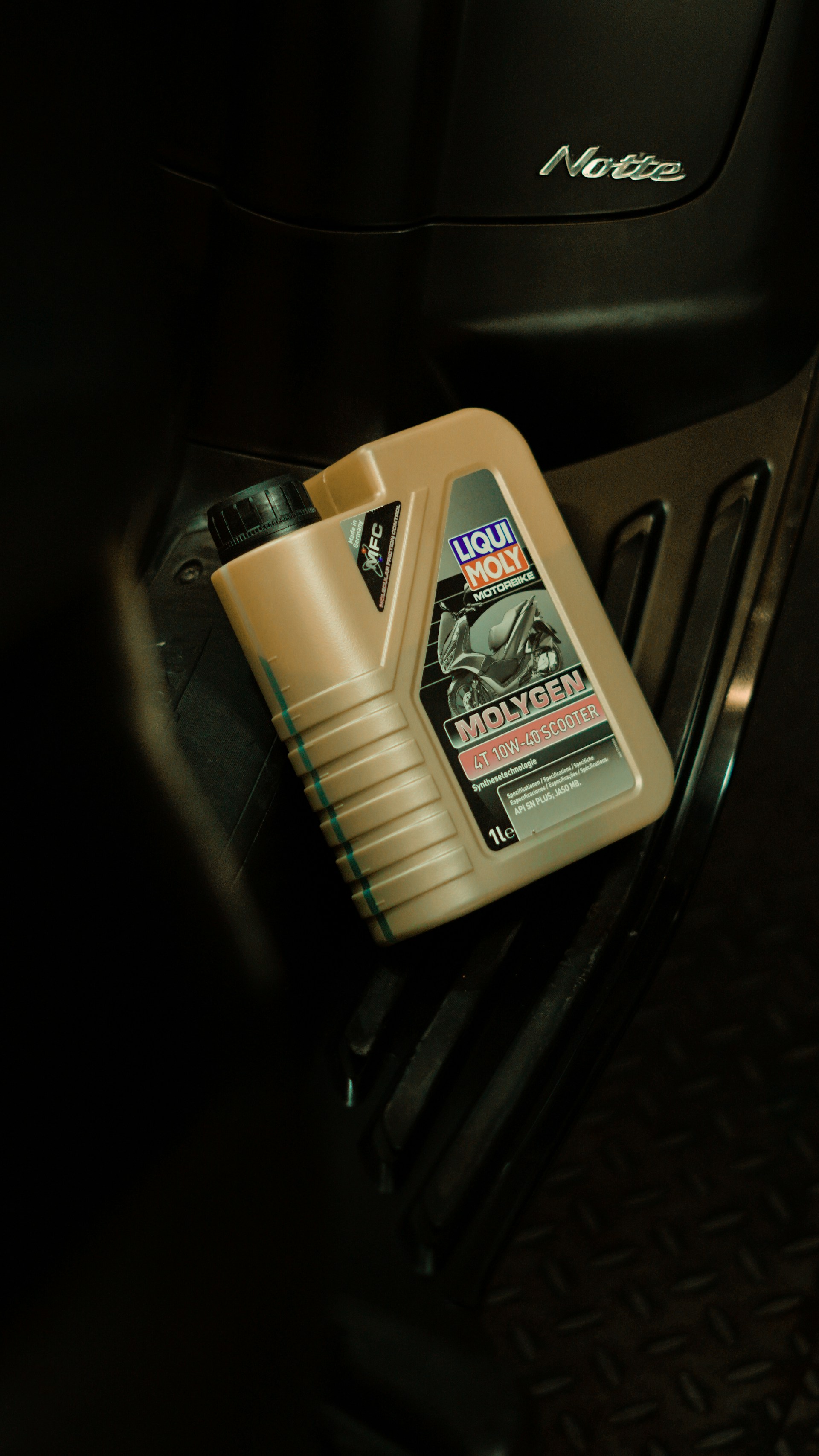 Oil bottle resting on a scooter.