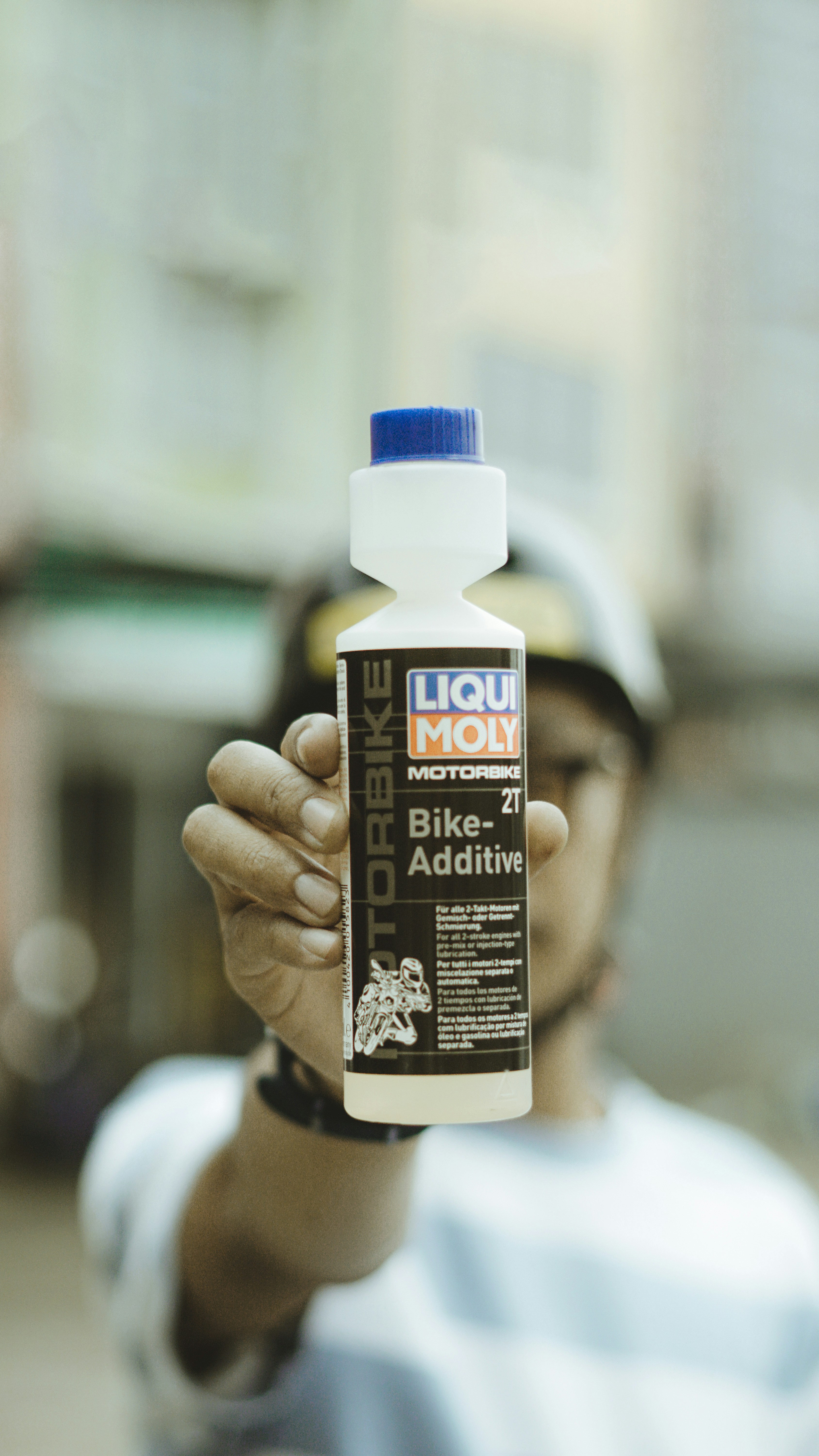 شخص يحمل زجاجة من مادة مضافة للدراجات.
