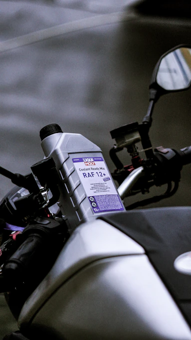 A bottle of coolant on a motorcycle.