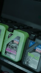 Motorcycle oil bottles on a shelf.